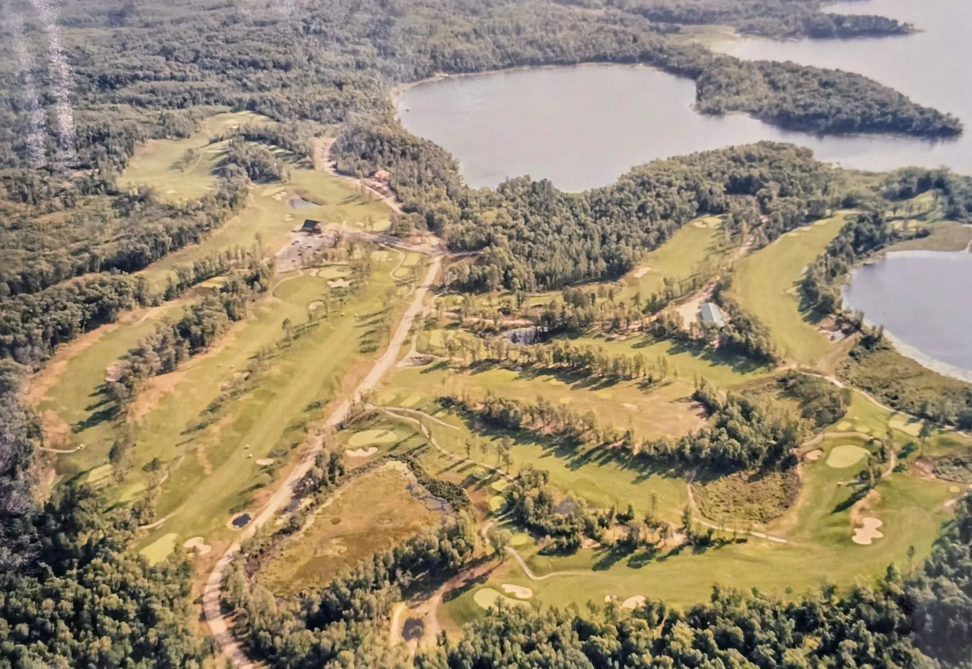 Aerial view of Golden Eagle's 210-acre property with fairways winding through the Northwoods and Eagle Lake beyond