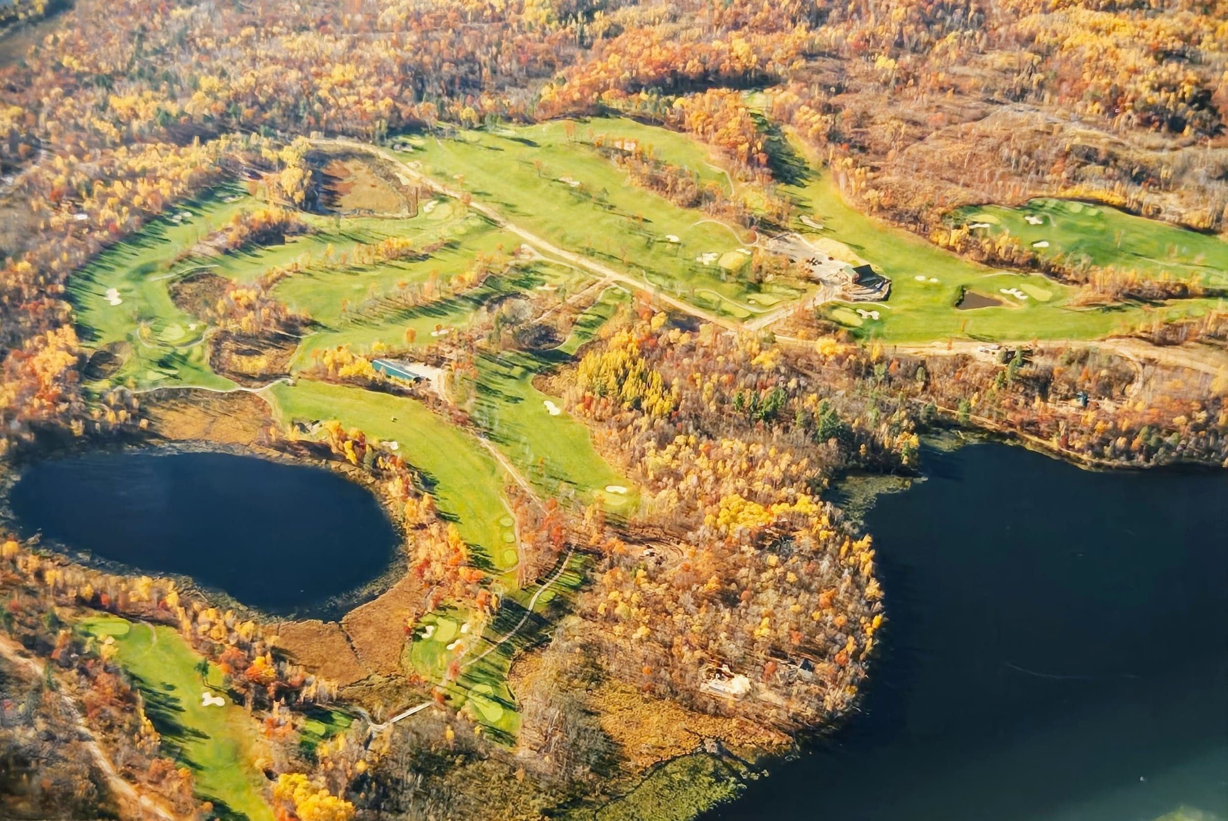 Fall aerial of Golden Eagle Golf Club, 18 holes woven through autumn-colored Northwoods forest and lakes