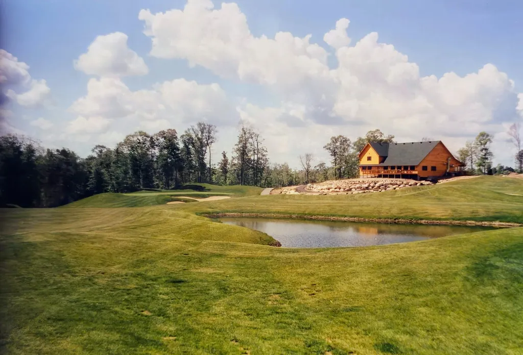 Golden Eagle clubhouse with pond and green in the foreground on a summer day