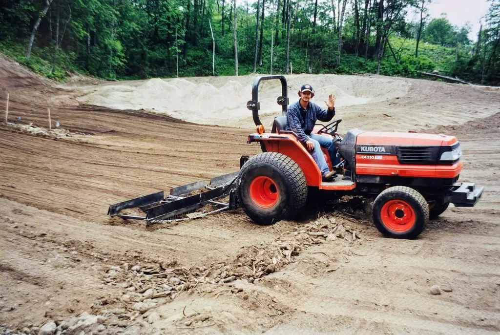 A worker on a Kubota tractor shaping a bunker during Golden Eagle construction