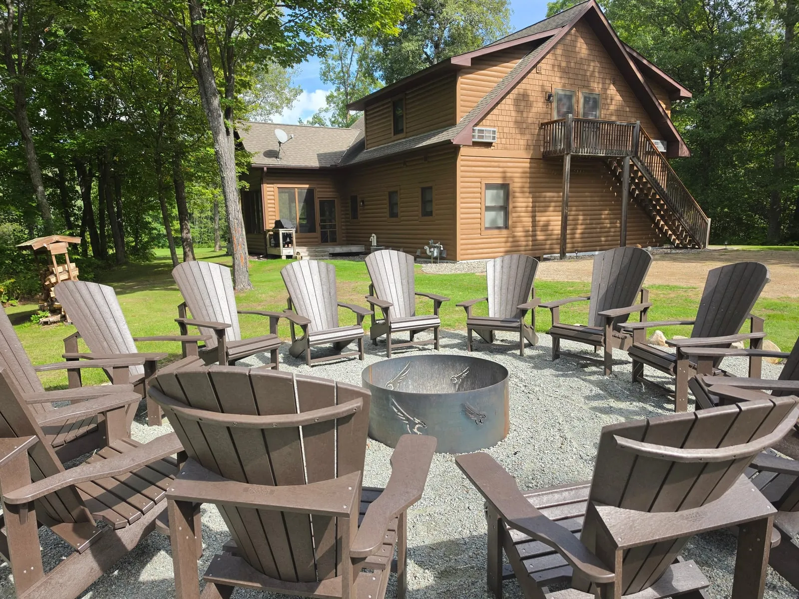 Circle of Adirondack chairs around an eagle-cut steel fire pit behind the Golden Eagle Cottage