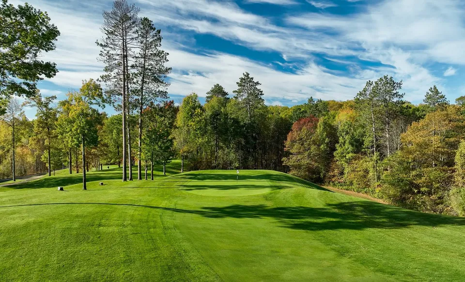 Vertical fairway view rising toward an elevated green