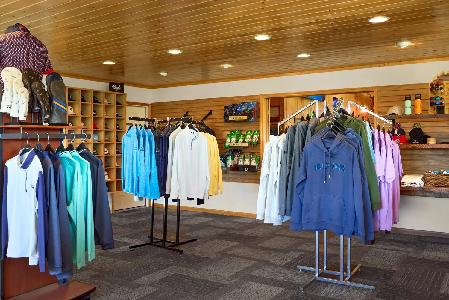 Golden Eagle pro shop merchandise display with hats, apparel, and logo'd gear