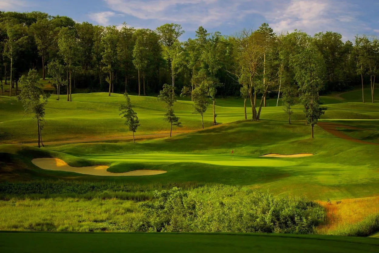 Sweeping Golden Eagle fairway view with bunkers, green, and surrounding Northwoods