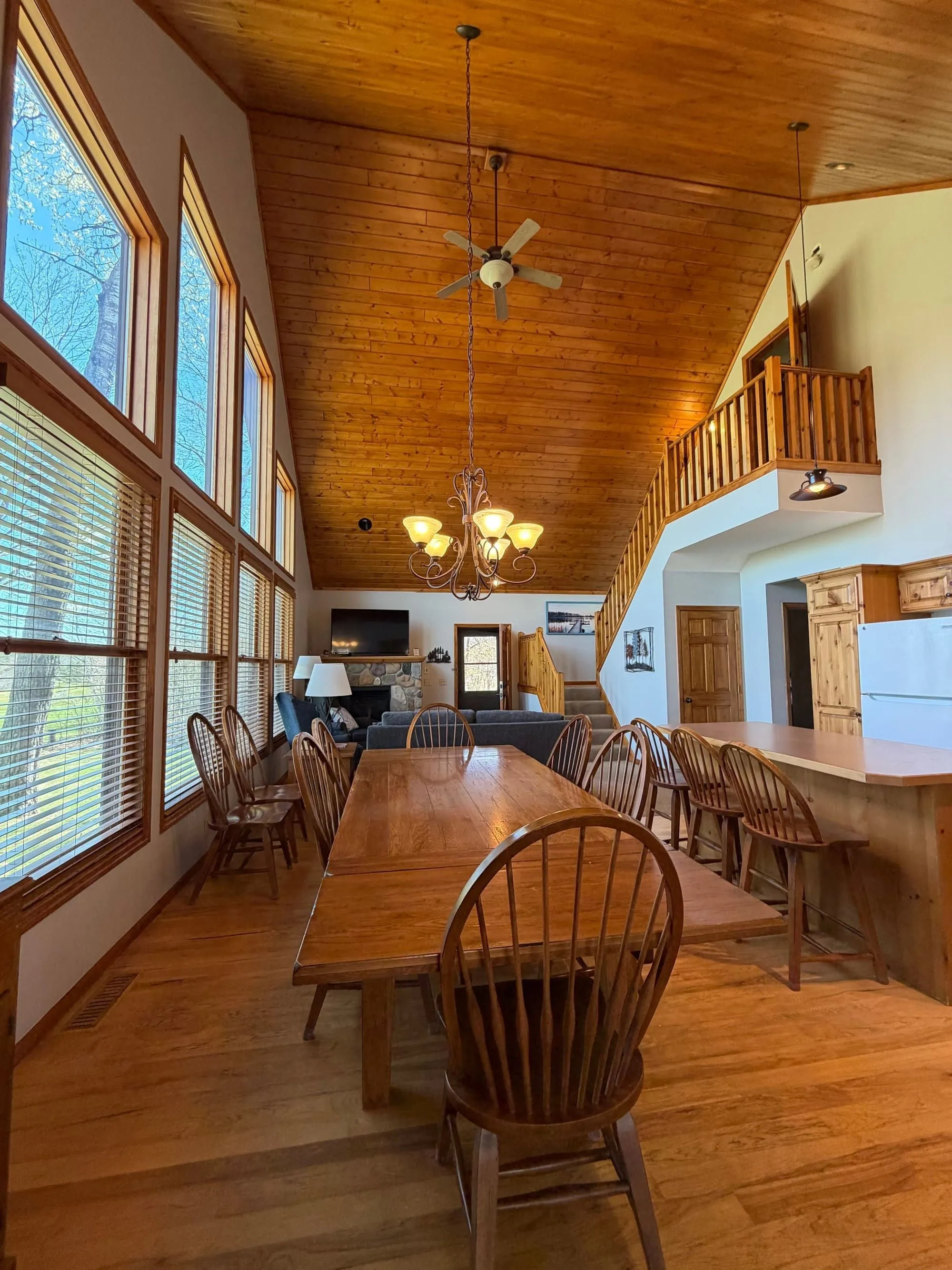 Vaulted great room with kitchen, dining, and stone fireplace inside the cottage's lower two-bedroom suite