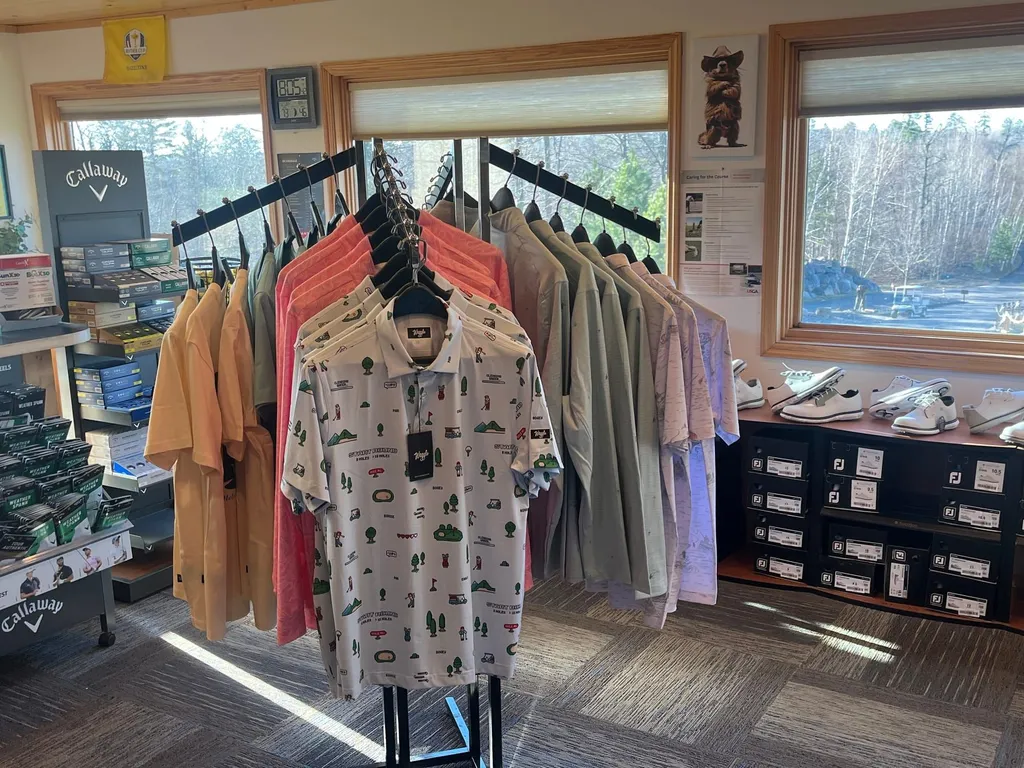 Patterned polos on display next to a Callaway showcase and FootJoy shoes inside the pro shop
