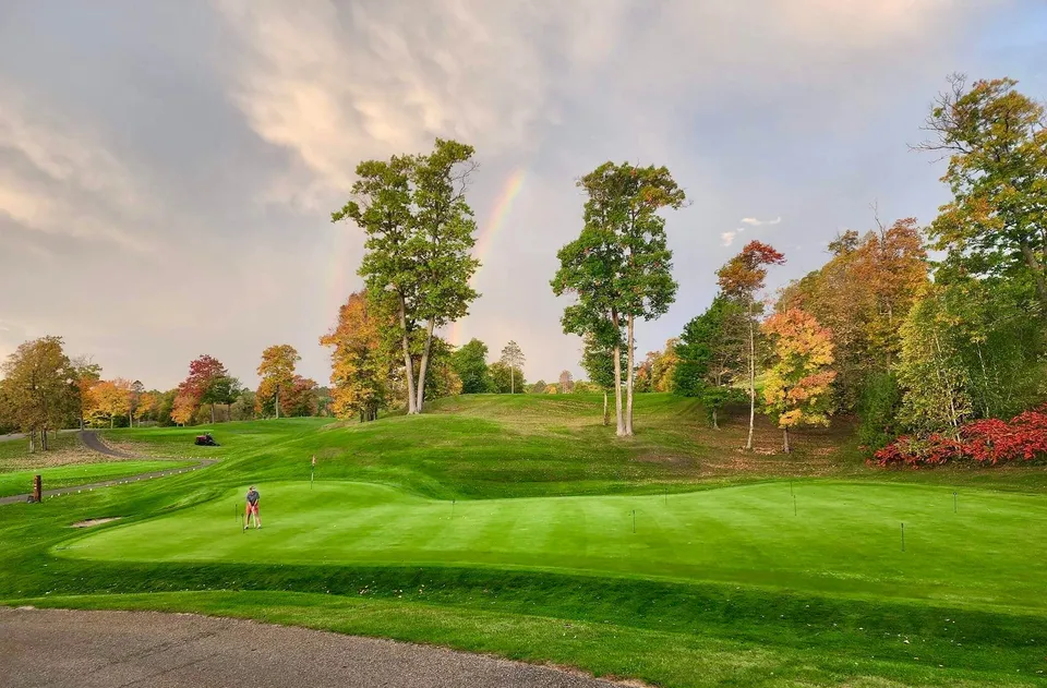 Practice putting green from ground level with the clubhouse in the background