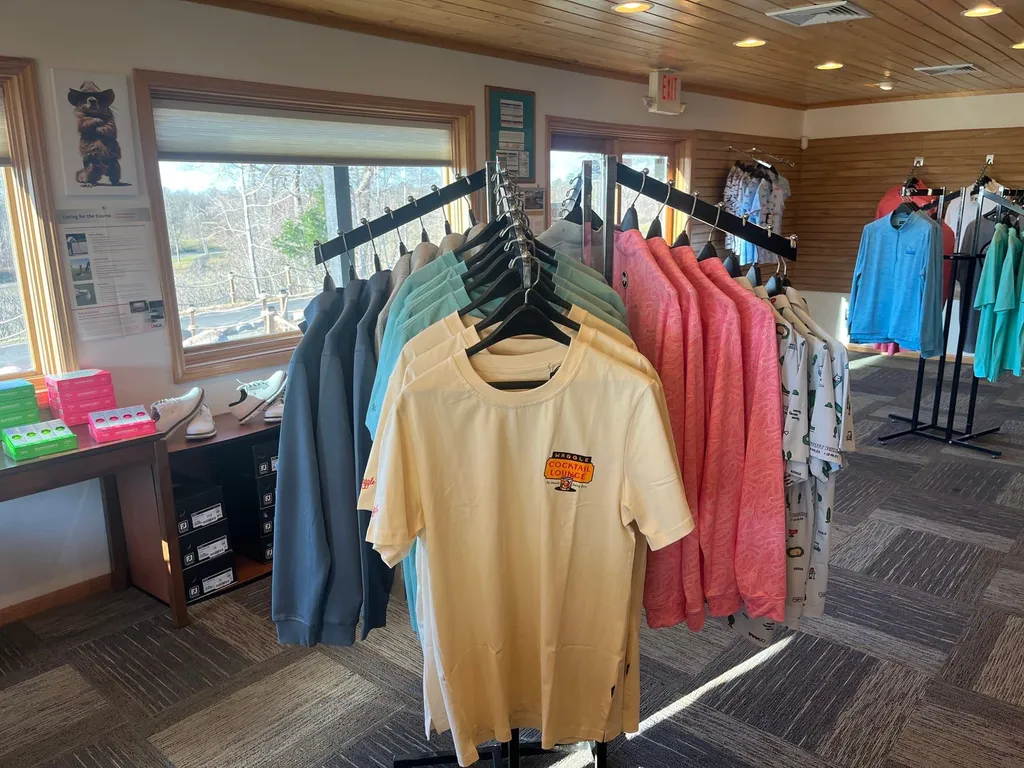 T-shirts and casual apparel on racks beside the pro shop windows